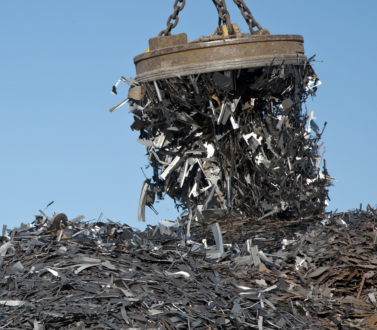 Photo of steel scrap being picked up by large magnetic crane