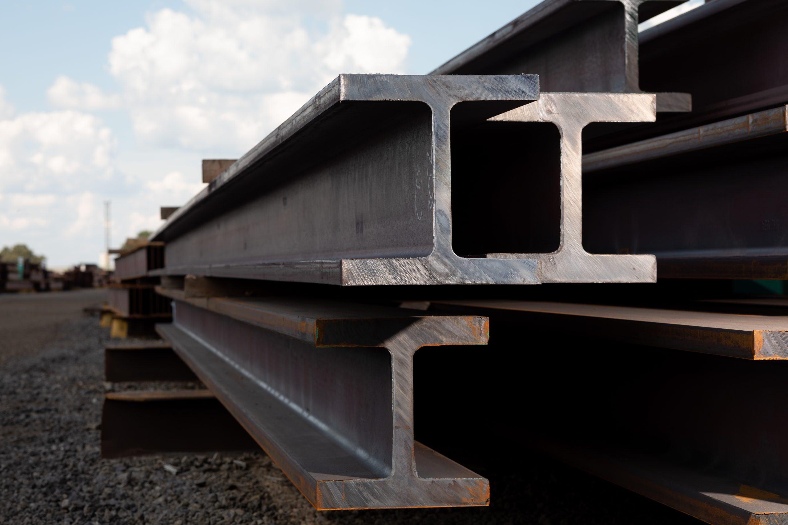 Photo of Nucor steel beams outside stacked on top of each other