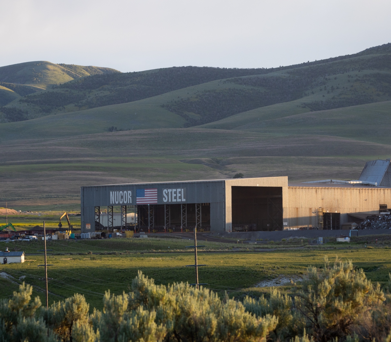 photo of the exterior of Nucor Steel Utah in front of a beautiful mountain range